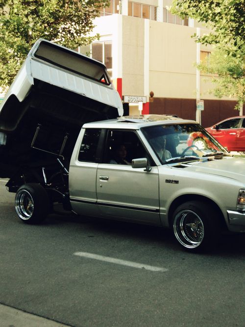 Free A custom lowrider pickup truck with opened bed cruises down an urban street. Stock Photo
