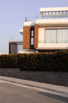 Elegant modern villa with wooden accents and lush greenery in urban setting.