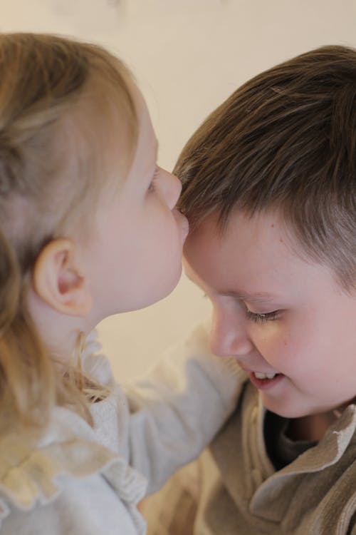 Free Sister Kissing Brother in Forehead Stock Photo