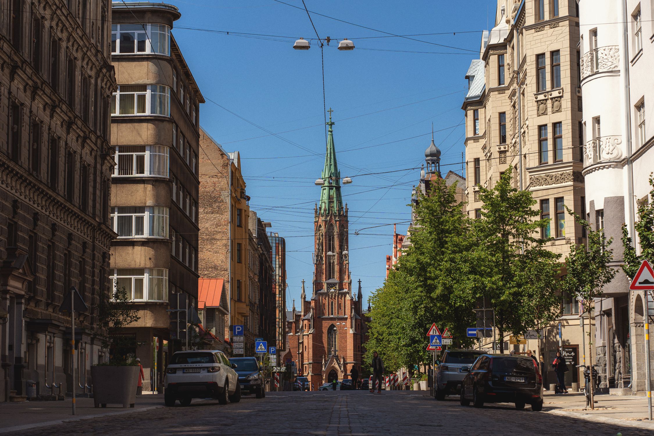 A picturesque street view of St. Gertrude Old Church in Riga, Latvia on a sunny day.