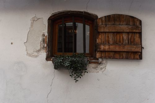 Free Charming old window with rustic wooden shutters and ivy in urban Riga, Latvia. Stock Photo