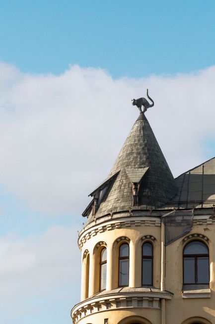 Close-up of the Cat House tower's iconic cat sculpture under a clear blue sky in Riga, Latvia.