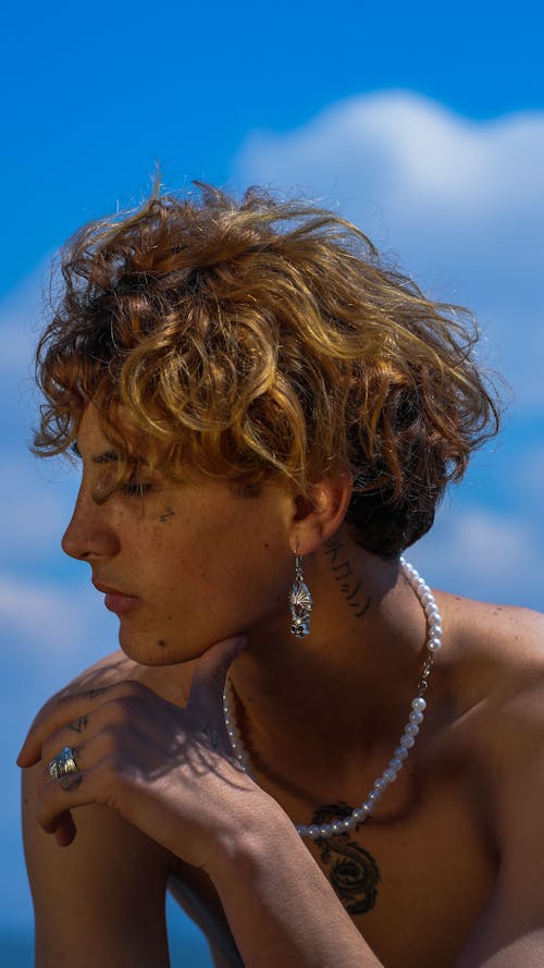Man with Dyed, Blonde Hair Posing Topless with Earring and Necklace