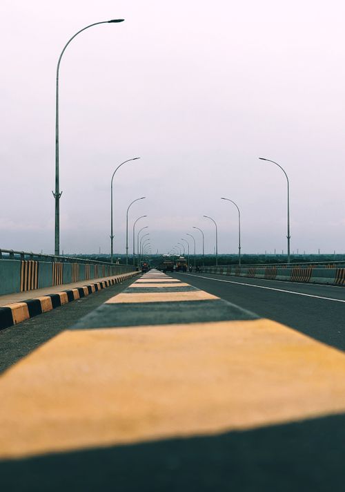 Free Lonely highway in Khulna, Bangladesh with bold yellow lines and streetlights. Stock Photo