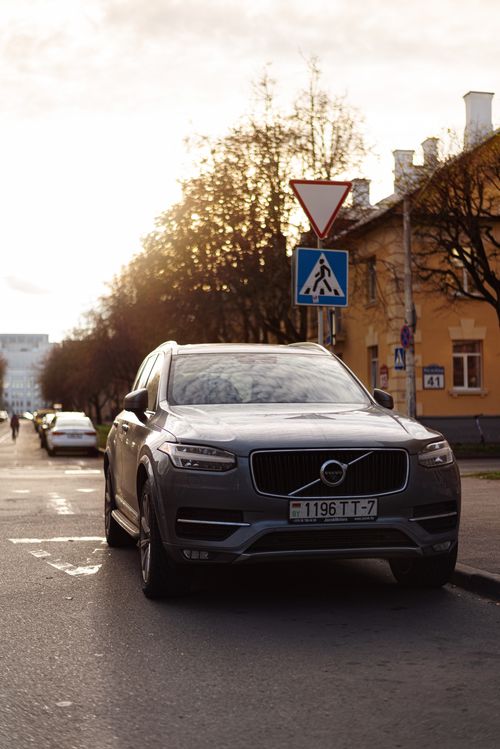 Free A Volvo XC90 parked on a city street with a beautiful sunlight backdrop. Stock Photo