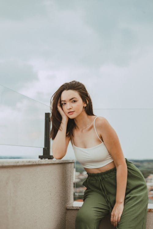 Woman Posing in Tank Top and Green Pants