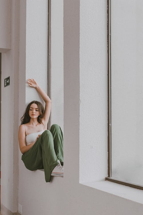 Brunette Woman in White Top Posing on Windowsill