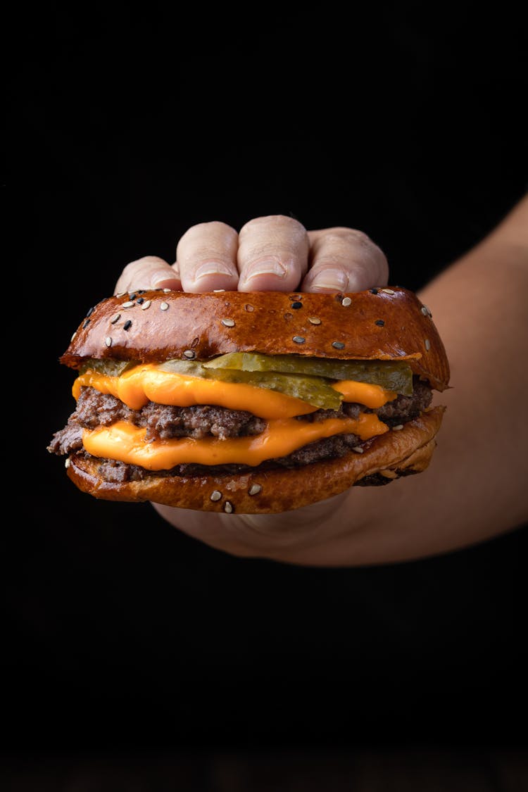 Hand Holding Cheeseburger