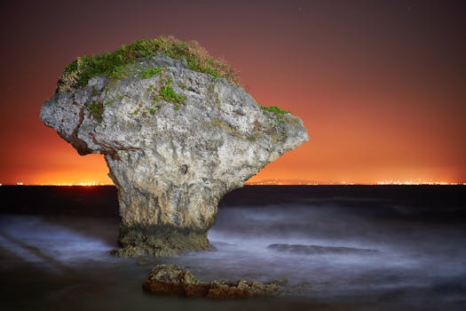 台湾小刘丘，绿树成荫，映衬着橙色的天空，夜色中的花瓶岩格外迷人