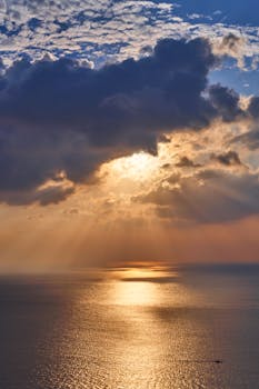 迷人的太阳在海洋上落山，照亮云层并映出宁静的倒影