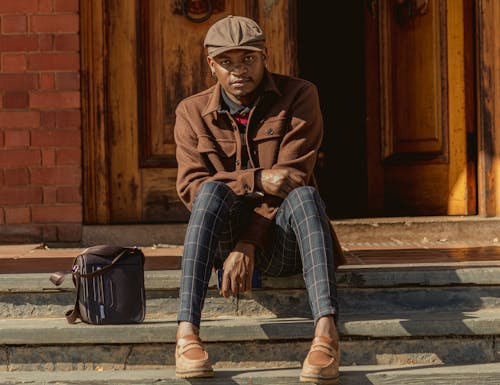 Elegant Man in Brown Jacket Sitting on Stairs on Street