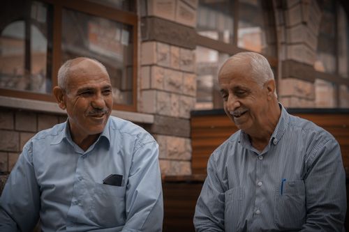 Free Two senior men smiling and talking outside, capturing a candid moment in Elâzığ, Türkiye. Stock Photo
