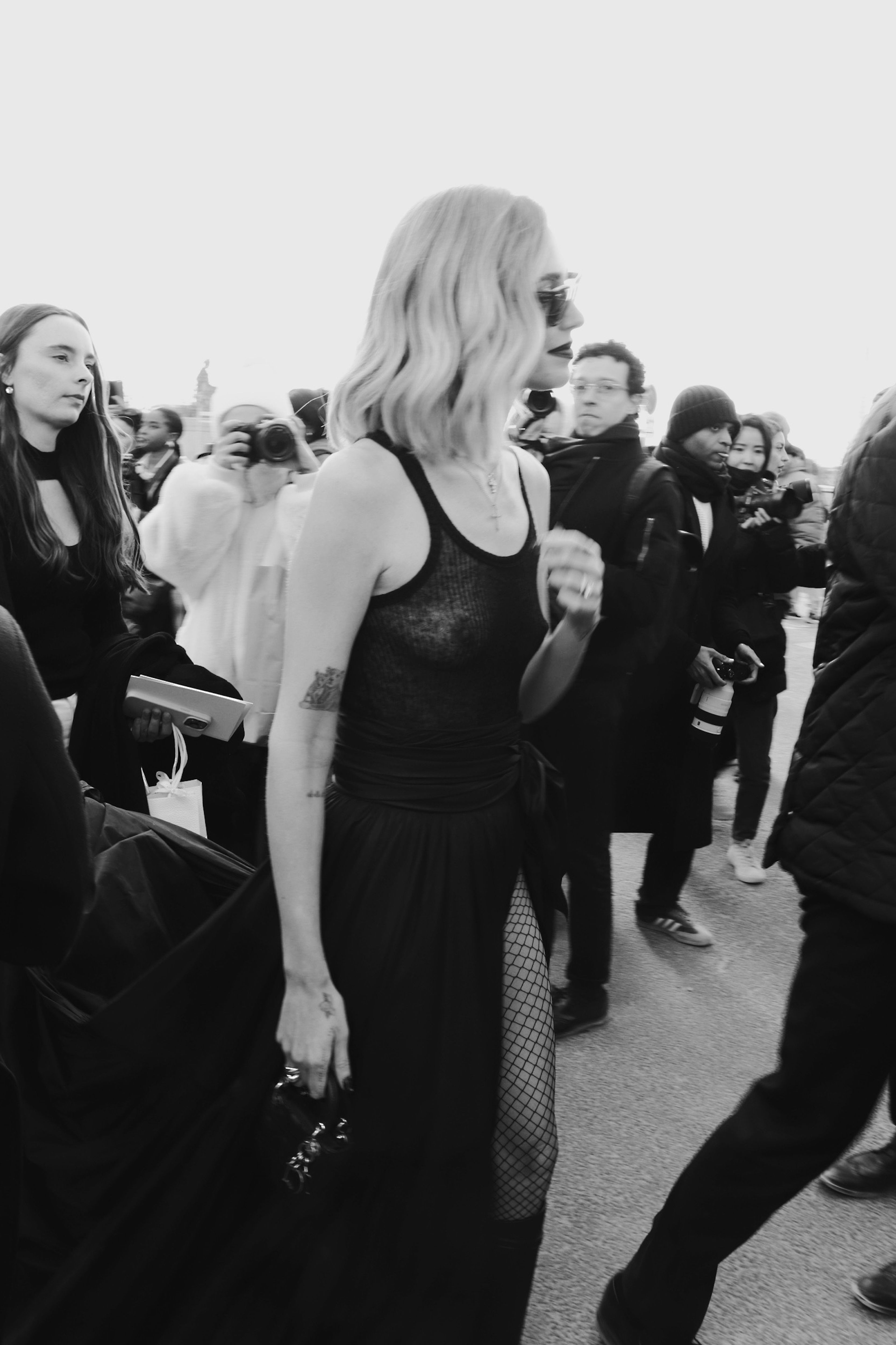 A woman in a black dress walking down the street · Free Stock Photo