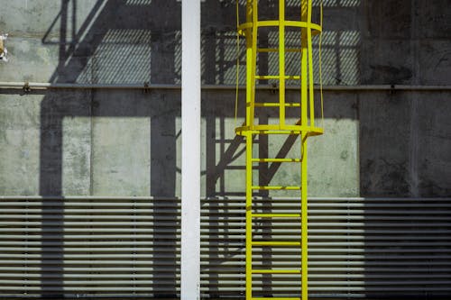 Exterior of a Concrete Building with Pipes and a Ladder 