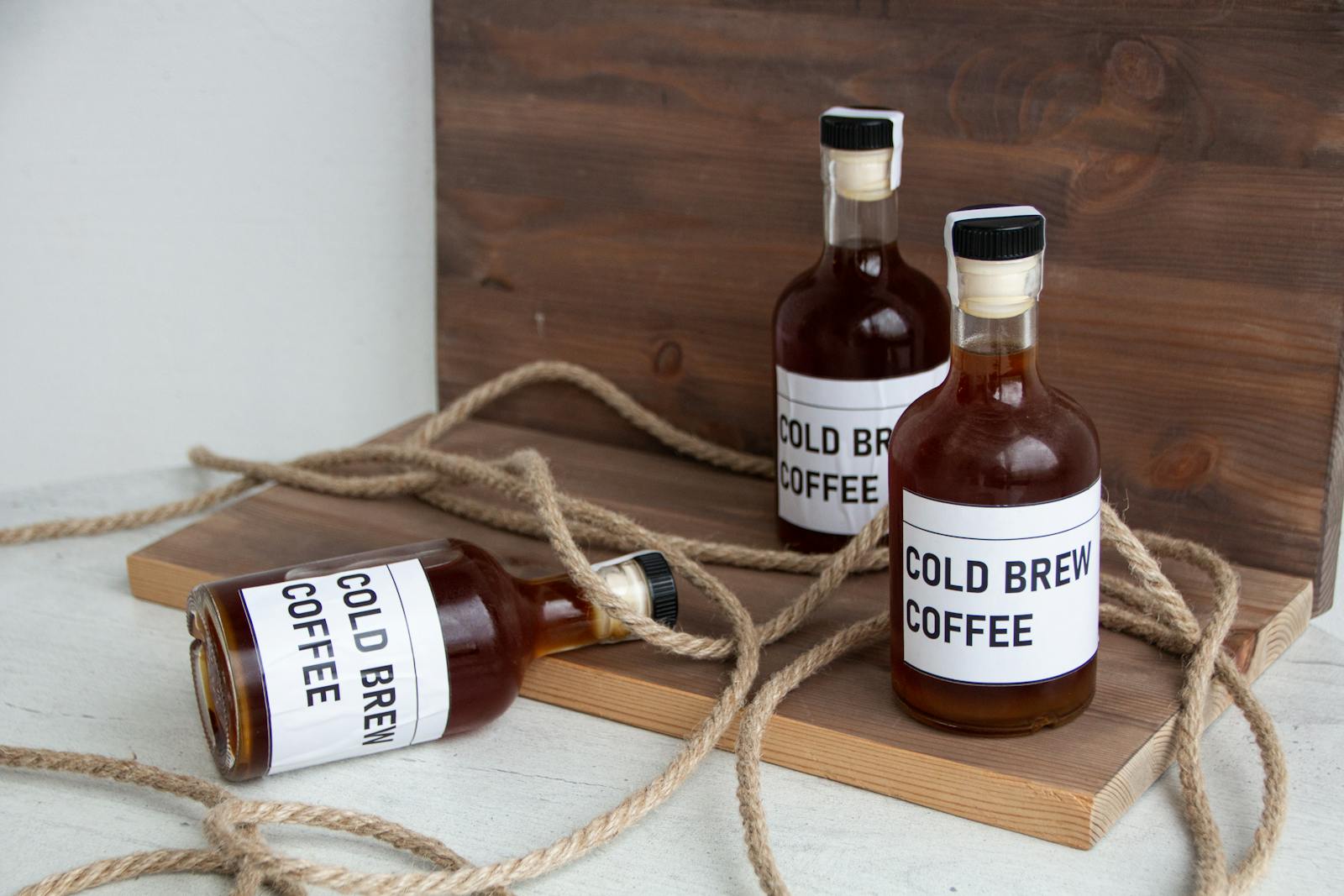 Bottles of cold brew concentrate on a rustic board
