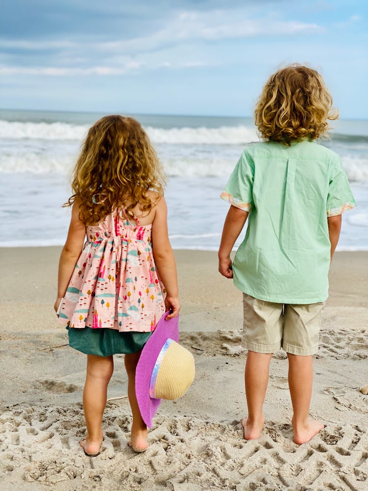 Boy And Girl Standing On Beach