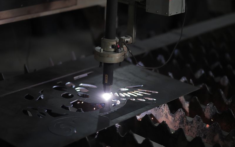 CNC plasma cutting a metal sheet with sparks