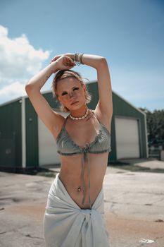 Elegant woman posing in stylish beachwear outside on a sunny day.