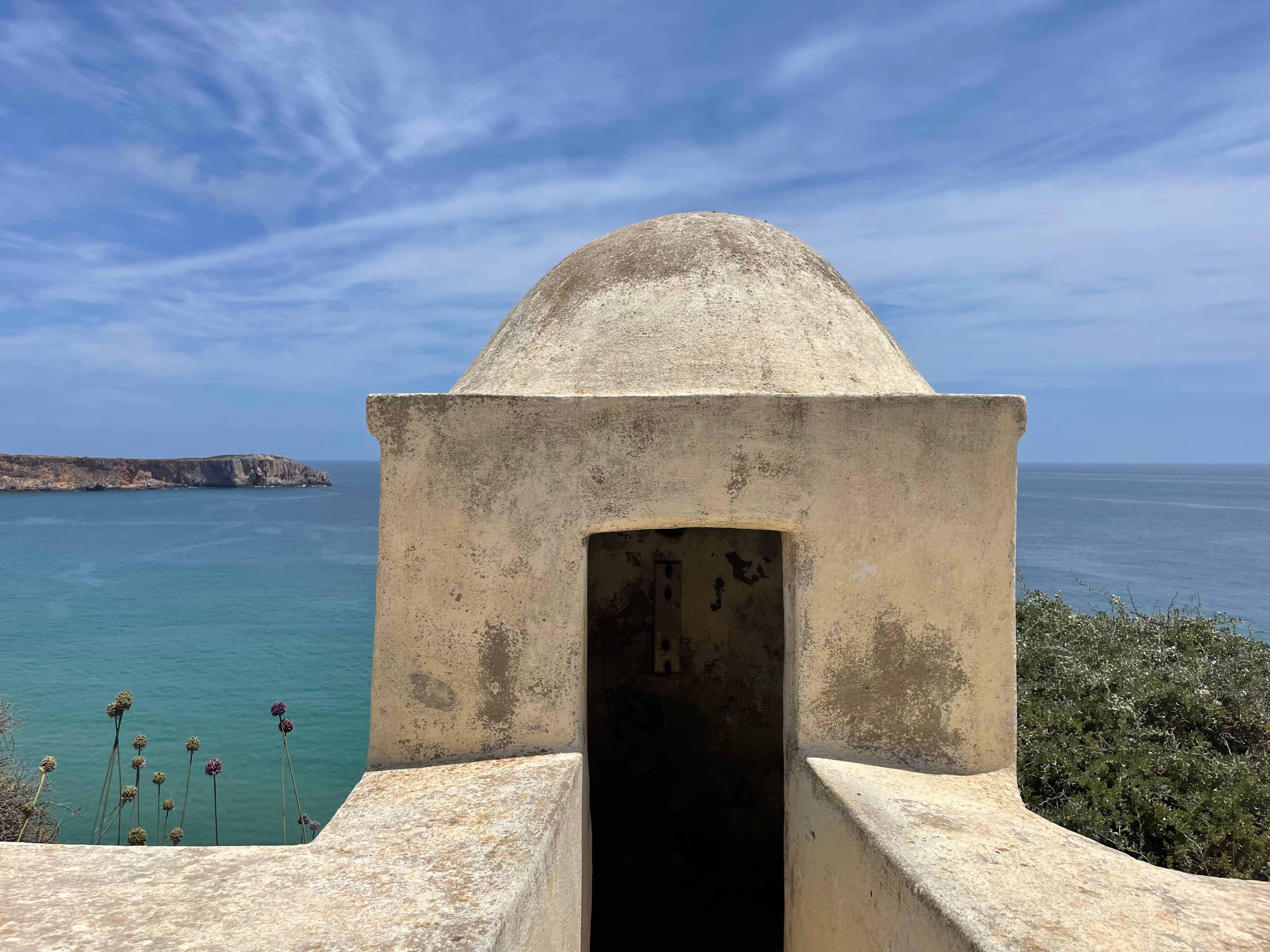 Old fortification with sea view under clear sky, capturing ancient architecture and serene coastline.