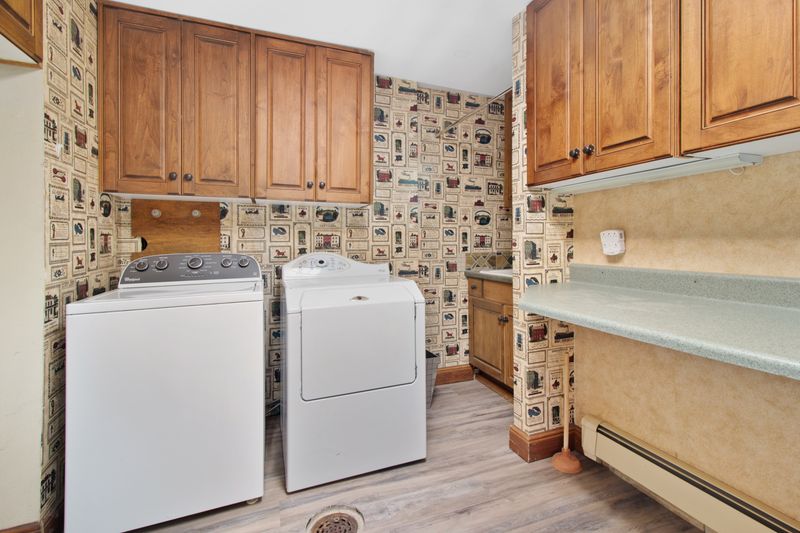 Compact laundry area with wooden cabinets and stacked machines