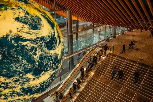 Globe over People on Stairs and Escalators