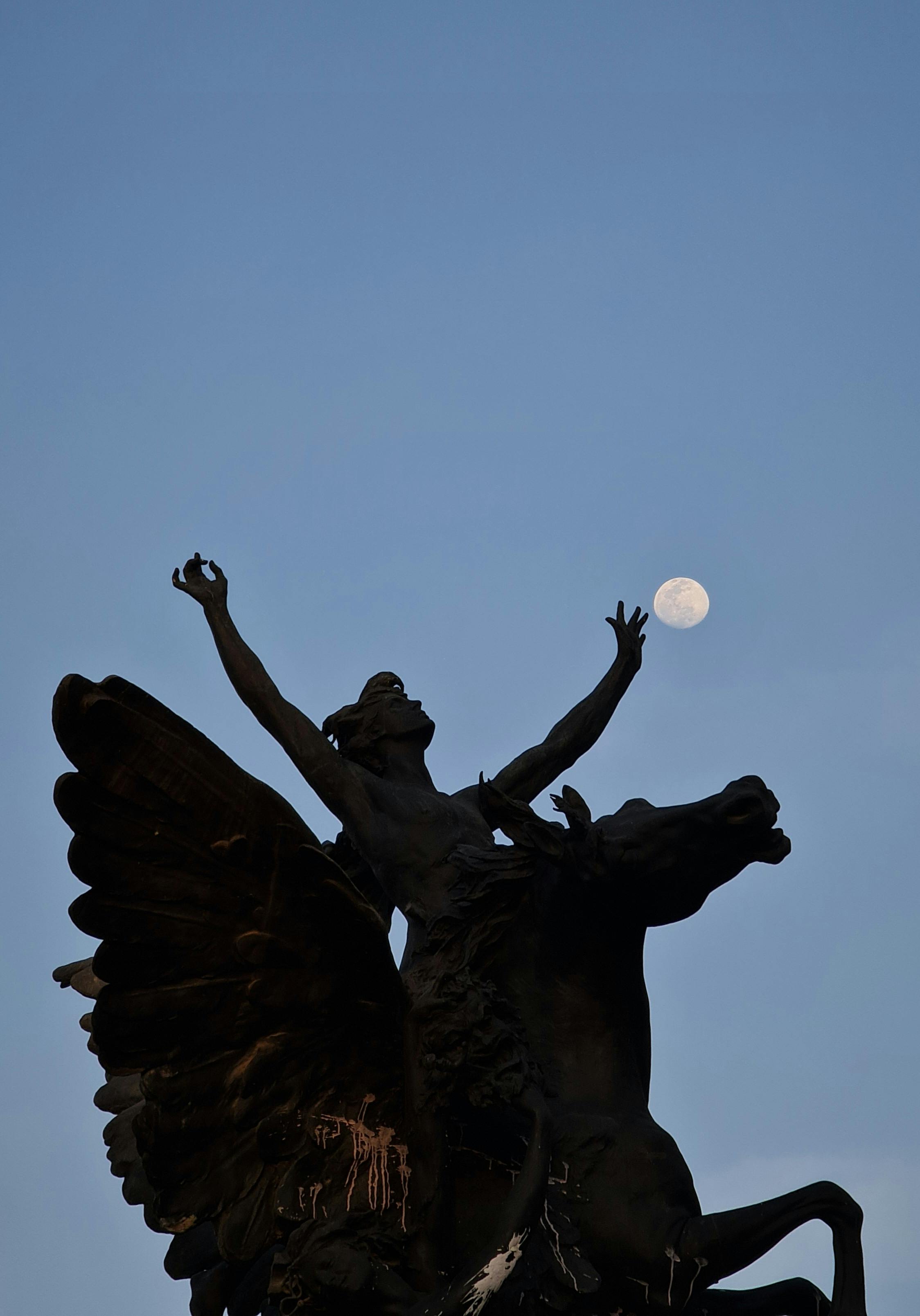 bronze sculpture of a rider on a pegasus catching the moon