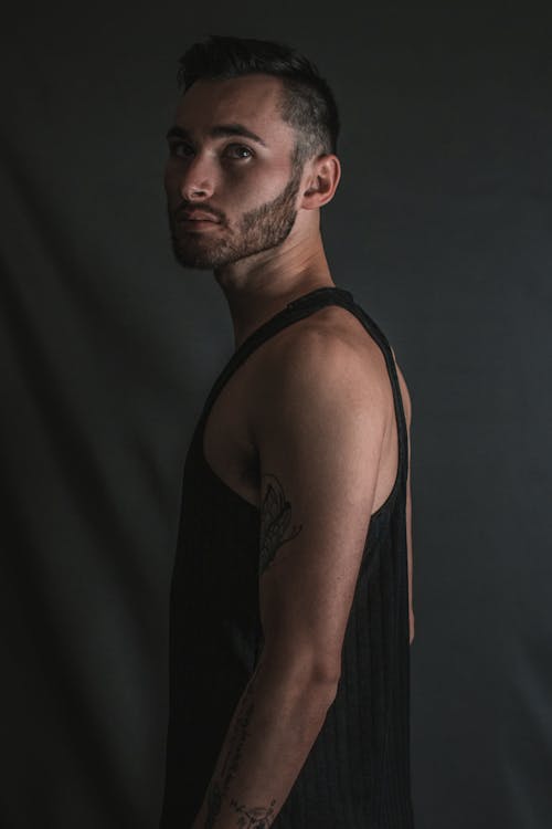 Man in a Black Tank Top Standing Sideways