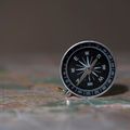 Compass resting on a folded map — photo by Саша Алалыкин on Pexels