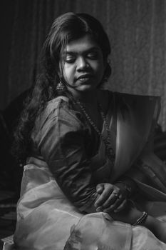 Black and white portrait of a South Asian woman in a sari, evoking elegance and tradition.