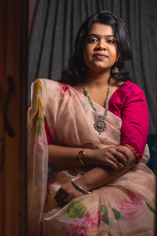 Woman in Magenta Blouse and Pink Sari Wearing a Necklace with Pendant