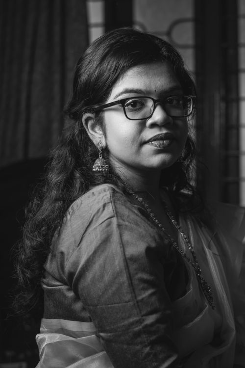 Free Elegant black and white portrait of a young woman with eyeglasses and traditional earrings. Stock Photo