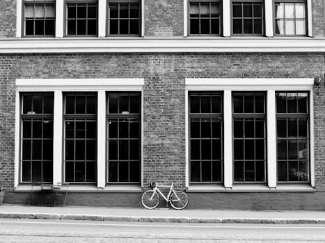 A bicycle leans against a brick building facade on a city street in Helsinki, Finland.
