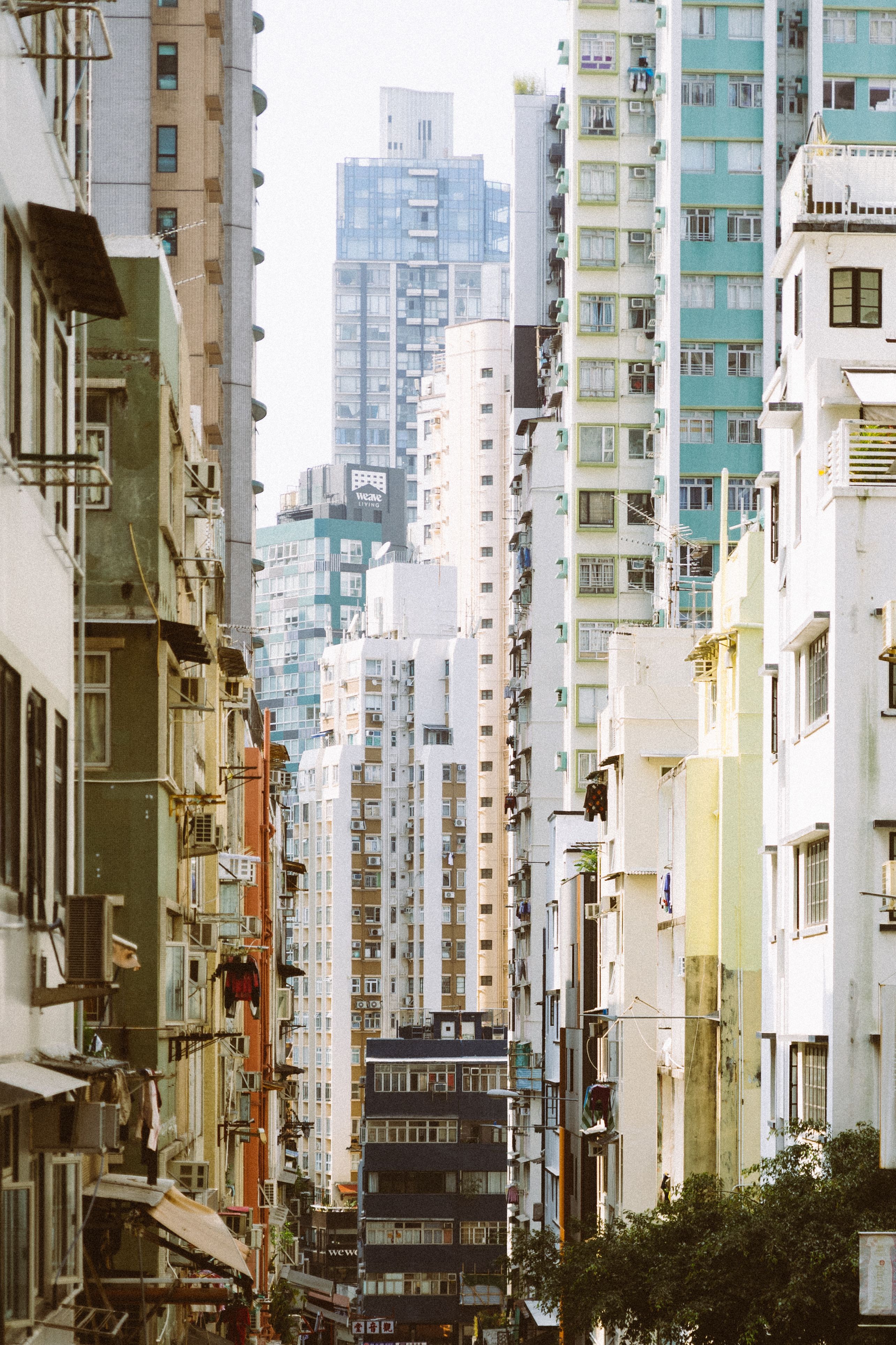 Fotomural Vista vertical de coloridos edificios residenciales de gran altura en una calle bulliciosa de Hong Kong.