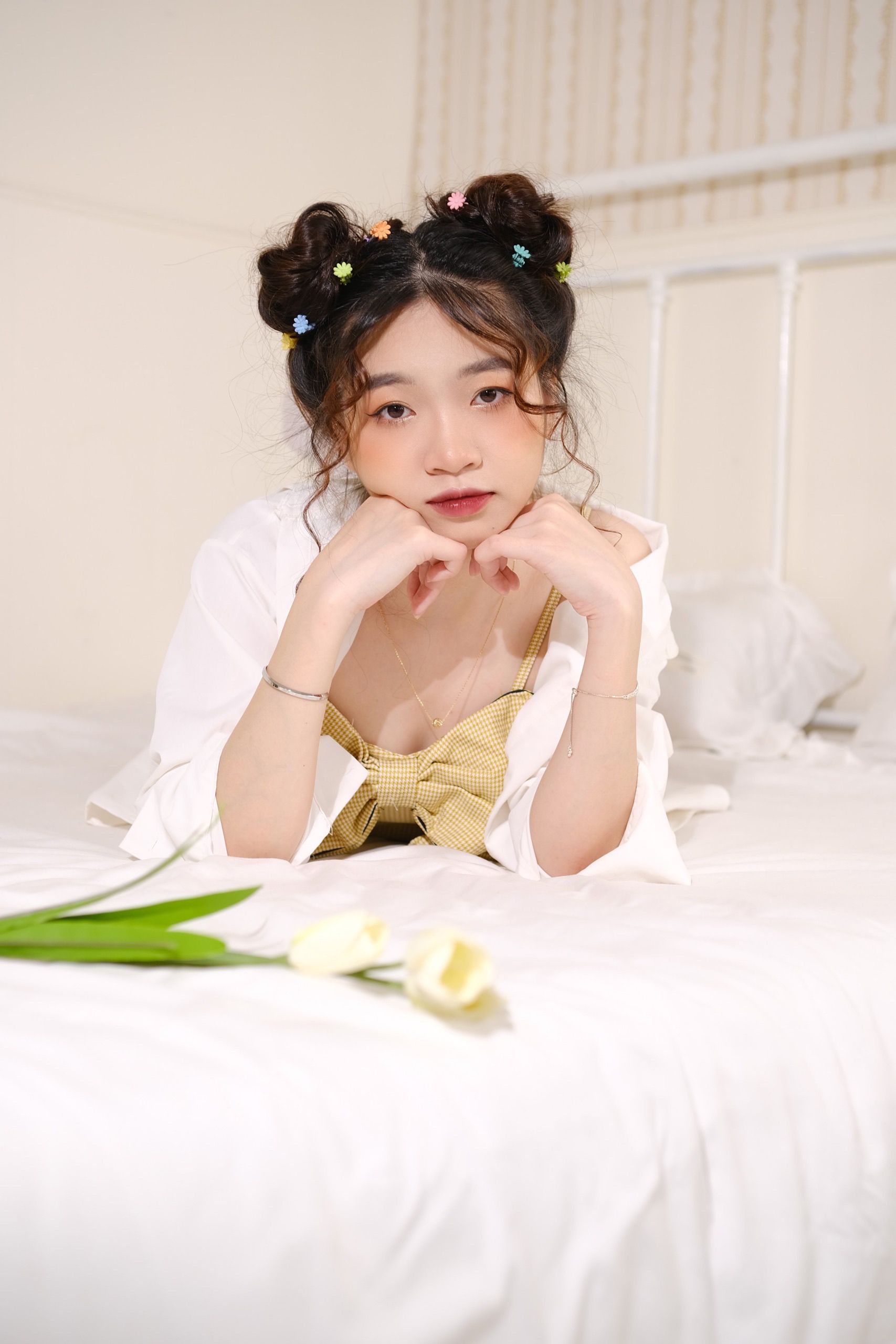 Young woman with braided hair in a bed surrounded by tulips, exuding a calming spring vibe.