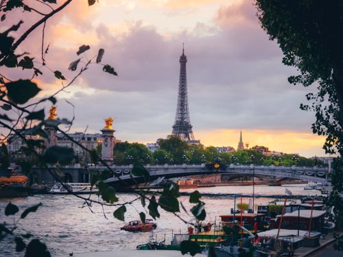 Free Beautiful sunset view of the Eiffel Tower over the Seine River in Paris, showcasing iconic French architecture. Stock Photo