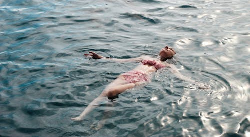 Photo of a Woman Wearing a Swimsuit Floating on Water