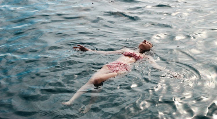 Photo Of A Woman Wearing A Swimsuit Floating On Water