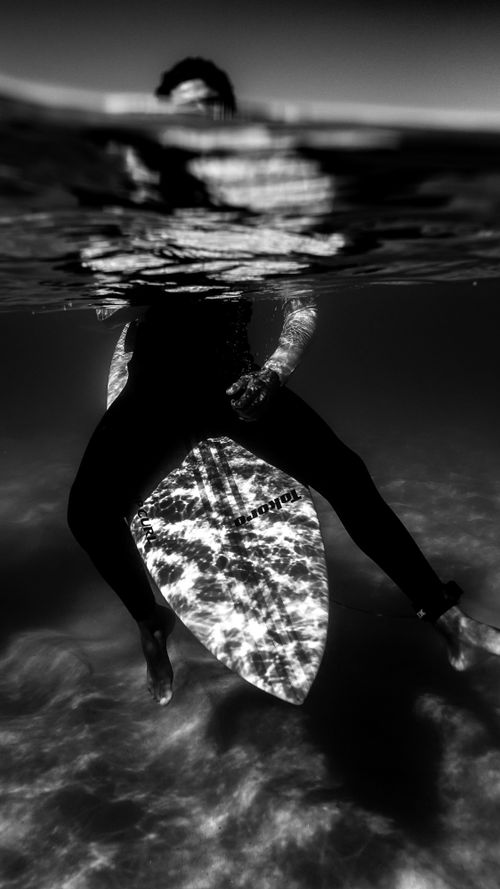 Free Moody underwater view of a surfer with a surfboard in Rio's waters. Stock Photo