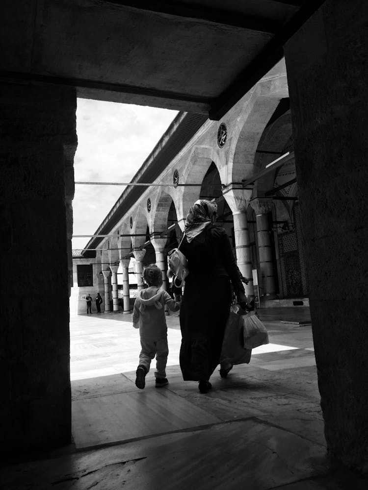 Mother And Child Walking In The Mosque Courtyard 