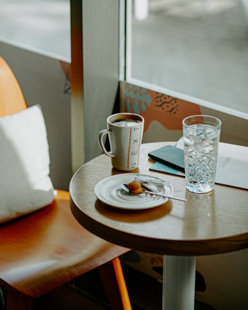 bardak, bir bardak su, bir fincan kahve içeren Ücretsiz stok fotoğraf