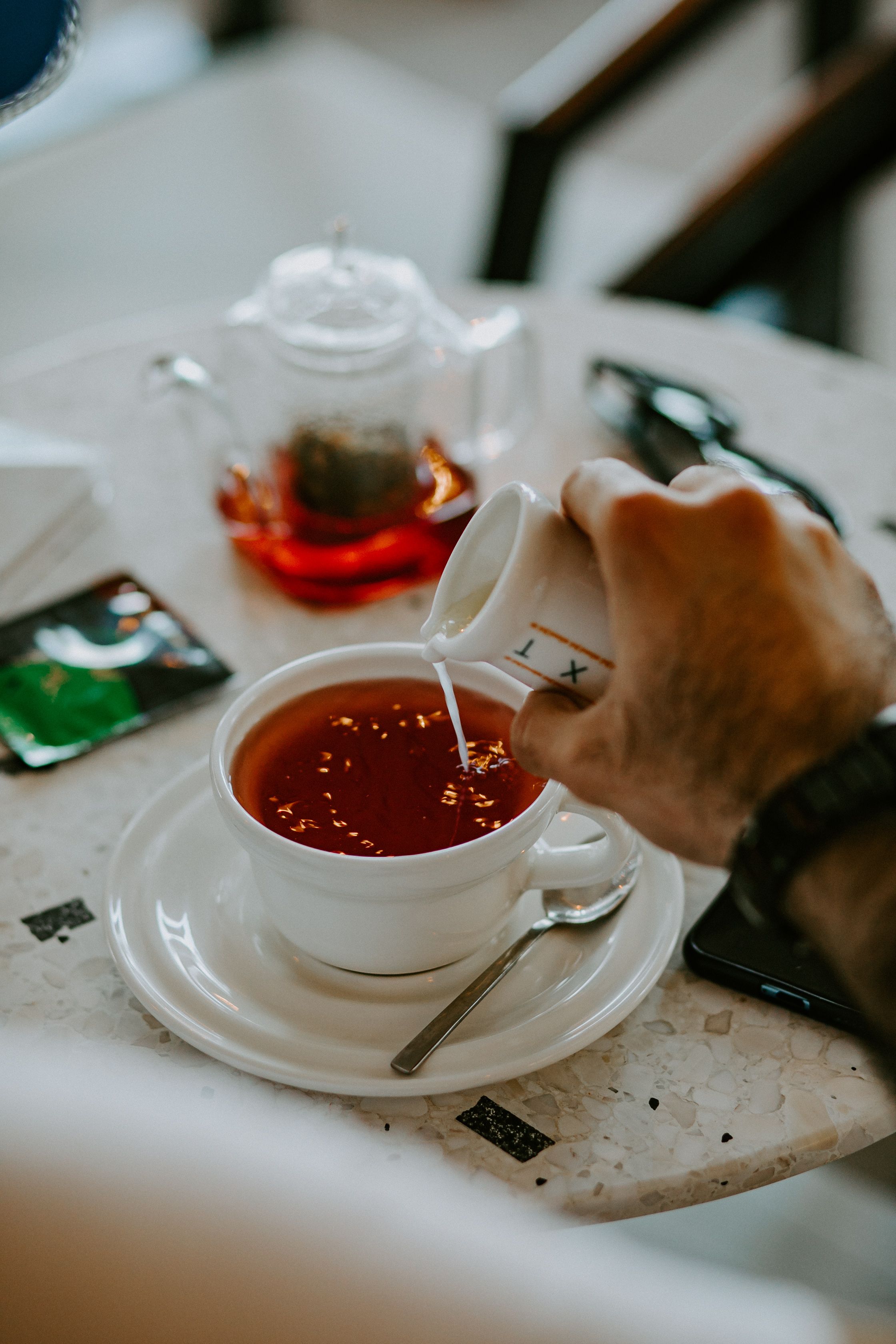 Close-up of Man Pouring Milk into His Tea · Free Stock Photo