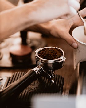 Barista preparing coffee with portafilter in Baku, Azerbaijan. Fresh, ground coffee focus.