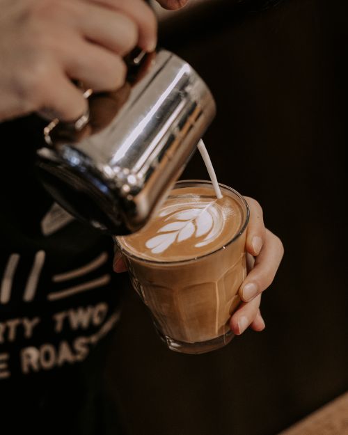 Free A barista pours milk into espresso, creating beautiful latte art in a cozy Baku cafe. Stock Photo