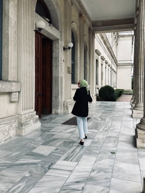Free A woman in a hijab and suit jacket walks through a historic building corridor in Istanbul, Turkey. Stock Photo