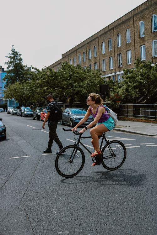 Free A cyclist riding through a busy street in London, showcasing urban life and city transportation. Stock Photo