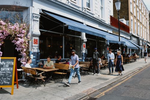 Free A lively city street with people dining at an outdoor café, perfect for brunch scenes. Stock Photo