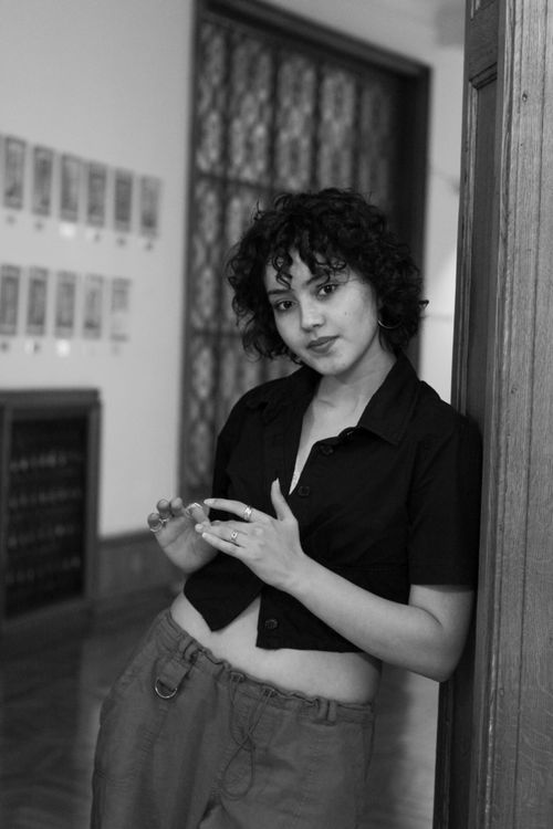 Free Chic black and white portrait of a young woman standing confidently in a doorway. Stock Photo