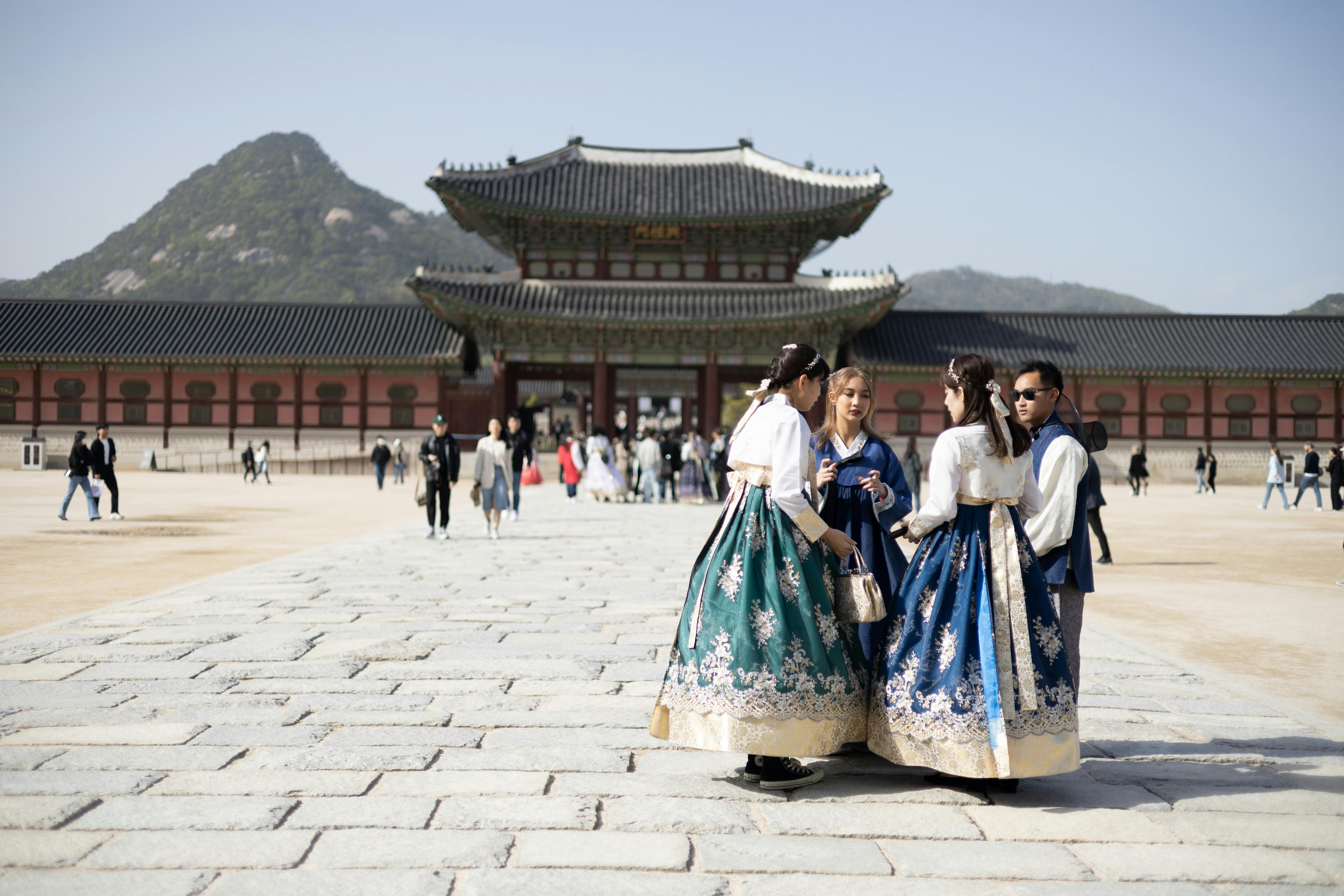 three women in traditional dress pose for a photo