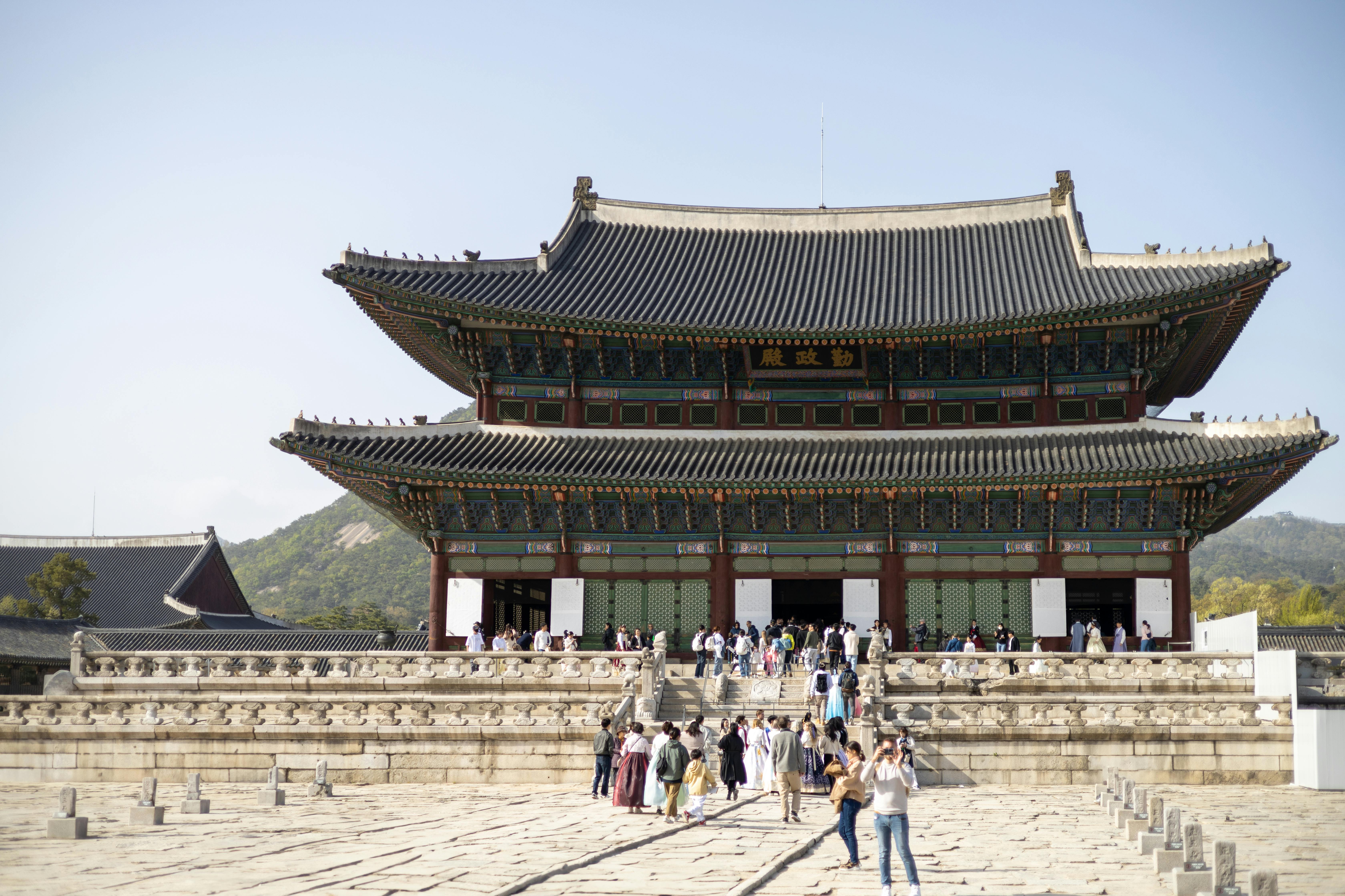 people are walking around a large building with a large pagoda