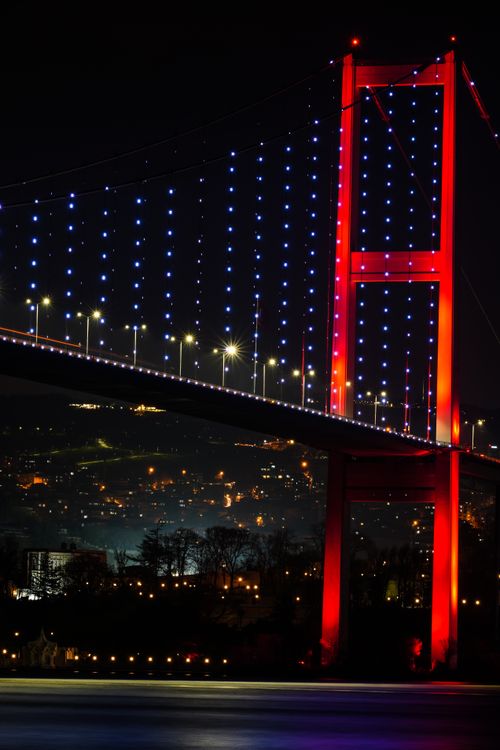 Free Stunning night view of the illuminated Bosphorus Bridge in Istanbul, showcasing vibrant red and blue lights. Stock Photo